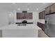 Modern kitchen with stainless steel appliances, gas range, quartz countertops, and dark cabinets at 2536 Vandra St, Las Vegas, NV 89138