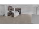 Open-concept living space with a kitchen island, stainless steel appliances, and neutral tile flooring at 2536 Vandra St, Las Vegas, NV 89138