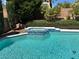 In-ground pool with attached hot tub and lush landscaping at 2817 Whispering Wind Dr, Las Vegas, NV 89117