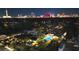 Aerial view of a home with a pool, lush landscaping, and a view of the city skyline in the background at 2822 Ashby Ave, Las Vegas, NV 89102