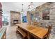 Rustic dining room with stone wall feature, wood floors, fireplace, and large windows for natural light at 2822 Ashby Ave, Las Vegas, NV 89102