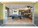 Open floor plan with game room, bar seating and partial kitchen view and bi-fold doors to patio at 2822 Ashby Ave, Las Vegas, NV 89102