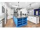 Bright kitchen features a blue island, stainless appliances, granite countertops, and white cabinetry at 2822 Ashby Ave, Las Vegas, NV 89102