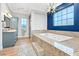 Luxurious bathroom showcasing soaking tub with tiled platform, large window, and vanity at 2822 Ashby Ave, Las Vegas, NV 89102