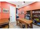 Home office featuring a large wooden desk, built-in shelves, and coral walls offering a creative workspace at 2822 Ashby Ave, Las Vegas, NV 89102