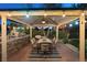 Outdoor kitchen with stone countertops, barbecue, bar seating, and stylish patio furniture beneath pergola at 2822 Ashby Ave, Las Vegas, NV 89102