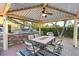 View of outdoor kitchen with patio dining table and ceiling fan at 2822 Ashby Ave, Las Vegas, NV 89102