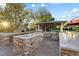 Gourmet outdoor kitchen with stone countertops, pizza oven, stainless grill, and covered seating area at 2822 Ashby Ave, Las Vegas, NV 89102