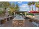 Covered outdoor kitchen area with stone counters, built-in grill, sink, pizza oven and lush landscaping at 2822 Ashby Ave, Las Vegas, NV 89102