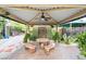 Charming patio area with a table and chairs under a covered space, complemented by vibrant greenery and stylish decor at 2822 Ashby Ave, Las Vegas, NV 89102