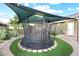 Backyard trampoline with safety net and sunshade next to a barrel sauna, creating a fun recreational space at 2822 Ashby Ave, Las Vegas, NV 89102