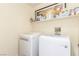 Efficient laundry room with modern washer and dryer, and storage shelves for supplies at 286 Fairmeadow St, Henderson, NV 89012