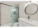 Modern bathroom with tiled shower, updated fixtures, and a round mirror above the sink at 3150 Soft Breezes Dr # 1037, Las Vegas, NV 89128
