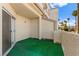 Private stucco patio with artificial turf and partial view of the neighborhood and palm trees at 3150 Soft Breezes Dr # 1037, Las Vegas, NV 89128