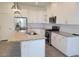 Modern kitchen featuring white cabinets, stainless steel appliances, and an island with a granite countertop at 3210 Centano Ave, Henderson, NV 89044