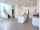 Open living space with stairs and bright open kitchen featuring stainless appliances and white cabinets at 3210 Centano Ave, Henderson, NV 89044