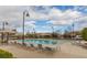 A refreshing community swimming pool surrounded by lounge chairs, umbrellas, and lush landscaping at 3210 Centano Ave, Henderson, NV 89044