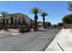 Gated community entrance with lush palm trees and meticulously maintained landscaping at 357 Whispering Tree Ave, Las Vegas, NV 89183