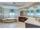 Luxurious bathroom with a soaking tub, dual sinks, tile flooring, and modern fixtures at 3633 Fox Heather Dr, Las Vegas, NV 89129