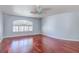 Bright bedroom featuring hardwood floors, white trim, arched window, and a modern ceiling fan at 3633 Fox Heather Dr, Las Vegas, NV 89129