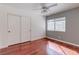 Cozy bedroom with hardwood floors, closet, a ceiling fan, and a large window at 3633 Fox Heather Dr, Las Vegas, NV 89129