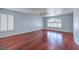 Spacious bedroom with hardwood floors, large windows with shutters, and a modern ceiling fan at 3633 Fox Heather Dr, Las Vegas, NV 89129