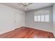Bedroom features hardwood floors, a closet, ceiling fan, and arched window at 3633 Fox Heather Dr, Las Vegas, NV 89129