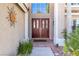 Elegant double front doors with decorative glass panels, flanked by lush greenery and desert landscaping at 3633 Fox Heather Dr, Las Vegas, NV 89129