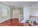 Bright hallway featuring hardwood floors, white trim, and a curved staircase with white banister at 3633 Fox Heather Dr, Las Vegas, NV 89129