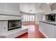 Open concept living area with fireplace, hardwood floors and an adjacent kitchen at 3633 Fox Heather Dr, Las Vegas, NV 89129