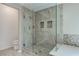 Modern shower with frameless glass door, gray tiling, bench, and dual recessed shelves at 3633 Fox Heather Dr, Las Vegas, NV 89129