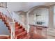 Elegant staircase with white railings, hardwood steps, and views into the adjoining living room with fireplace at 3633 Fox Heather Dr, Las Vegas, NV 89129