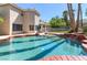 Backyard swimming pool with waterfall feature, surrounded by lush landscaping, creating a private oasis at 3633 Fox Heather Dr, Las Vegas, NV 89129