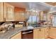 A bright kitchen includes neutral countertops, wooden cabinetry, and a view to the backyard at 364 Clark Dr, Henderson, NV 89074