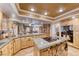 An open kitchen boasts bright, wooden cabinetry, an island cooktop, and an open design to the living area at 364 Clark Dr, Henderson, NV 89074
