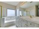 Bright bathroom featuring a dual sink vanity, soaking tub, standalone shower, and large mirror at 3766 Port Ritchey St, Las Vegas, NV 89147