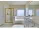 Bathroom featuring tiled floors, standalone shower with gold trim, soaking tub, and a dual sink vanity at 3766 Port Ritchey St, Las Vegas, NV 89147