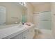 Bathroom featuring a wide mirror, a combination tub and shower, and white cabinets for plenty of storage at 3766 Port Ritchey St, Las Vegas, NV 89147