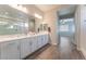 Bright bathroom features double sinks, white cabinetry, and wood look tile flooring at 421 Point Sur Ave, Las Vegas, NV 89138