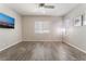 Comfortable bedroom with wood look tile flooring, ceiling fan and two windows at 421 Point Sur Ave, Las Vegas, NV 89138
