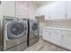 Modern laundry room with front load washer/dryer, white cabinetry and laminate countertops at 421 Point Sur Ave, Las Vegas, NV 89138