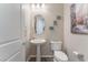 Charming powder room featuring pedestal sink, oval mirror and lovely wall decor at 421 Point Sur Ave, Las Vegas, NV 89138