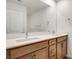 Bright bathroom featuring double sinks, a quartz countertop, ample lighting and wood style cabinets at 4349 Tabor Peak Ave, Las Vegas, NV 89141
