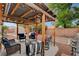 Backyard featuring a covered patio, outdoor seating, play structures, and mature trees at 5220 Shasta Daisy St, North Las Vegas, NV 89031