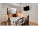 Cozy bedroom with a wrought iron bed frame and wall mounted TV at 5220 Shasta Daisy St, North Las Vegas, NV 89031