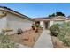 Home's front entrance featuring desert landscaping and a decorative security screen door at 5220 Shasta Daisy St, North Las Vegas, NV 89031