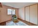 Cozy bedroom with a plush recliner, large sliding closet, and a window with sunlight and soft rug at 5274 Somerset Dr, Las Vegas, NV 89120
