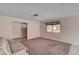 Spacious living room featuring neutral walls, carpet flooring, and natural light from the window at 5274 Somerset Dr, Las Vegas, NV 89120