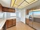 Kitchen view highlighting the open flow to a well-lit living room area with tiled floors and wood cabinets at 5460 Conville Pl, Las Vegas, NV 89120