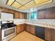 Functional kitchen featuring wooden cabinets, tile countertops and flooring with stainless steel appliances at 5460 Conville Pl, Las Vegas, NV 89120